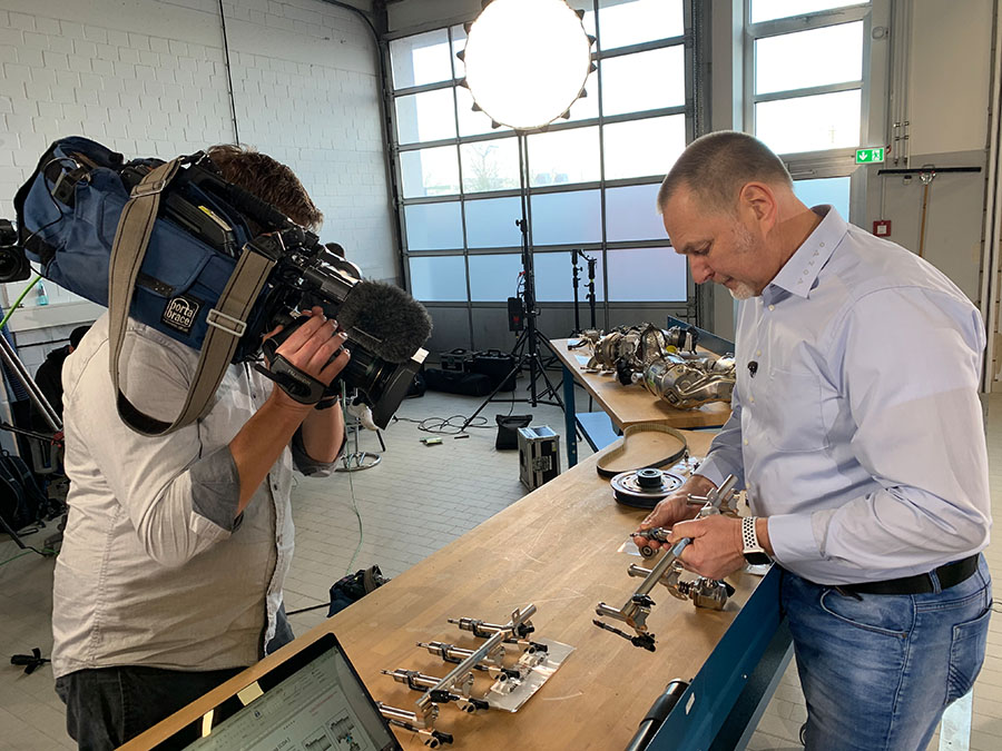 Shooting training video at a car manufacturer, tutor explains mechanics of engine parts